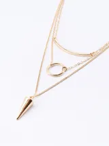 Collar de tres capas en tono dorado, compuesto por cadenas finas de eslabones. Presenta un diseño geométrico que incluye una barra curva, un círculo central y un dije en forma de cono o péndulo en la parte inferior.