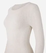 Suéter de punto acanalado color beige, con cuello redondo y mangas largas. Confeccionado en tejido tricot con textura suave y ajuste al cuerpo.