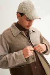 Camisa estilo leñadora con diseño patchwork en tonos marrones y beige. Presenta coderas, cartera americana y bolsillo ojal en el delantero. Confeccionada en Uruguay con tela 100% lana fina sin teñir.