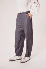 Pantalón gris a rayas verticales blancas, de corte recto y tiro medio.