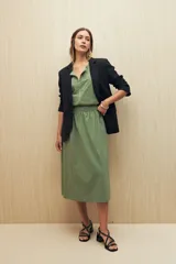 Chaleco color beige sin mangas de silueta relajada, con escote redondeado, cierre frontal con cremallera y ruedo elastizado.