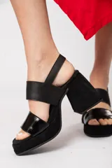 Sandalias negras de cuero con plataforma delantera de 3 cm y taco de 9 cm forrado. Tiene doble tira y ajuste con hebilla.