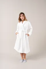 Bata de polar color blanco con textura labrada, corte clásico, cuello tipo chal y lazo para ajustar en la cintura.