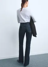 Jeans de tiro medio con corte flare y bajo deshilachado. Presentan diseño de cinco bolsillos, cierre frontal con cremallera y botón, y trabillas para cinturón.