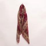 Pashmina color bordó con diseño estampado de guardas ornamentales y detalles florales en tonos beige y verde.