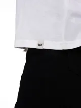 Remera blanca con cuello redondo y mangas cortas, confeccionada con un diseño de corte clásico. Presenta un pequeño estampado gráfico en el pecho con el texto "Caterpillar" y una flor dibujada.
