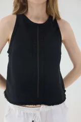 Top de jean blanco sin mangas, con escote redondo, espalda deportiva, costuras pespunteadas en el frente y ruedo desmechado.