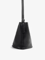 Cartera bandolera de cuero floater color negro, de diseño cilíndrico tipo bucket, con correa larga para llevar al hombro o cruzada y broche de imán.