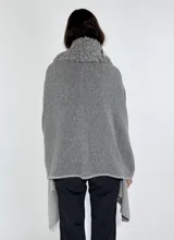 Ruana de lambswool color gris oscuro, con cuello alto y detalles bordados a mano en relieve en el cuello y a lo largo de la abertura frontal.