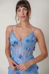 Vestido largo de fiesta en tul celeste pastel bordado con flores en tela. Tiene breteles finos, escote en V, top con ballenas y tajo alto en la pierna.