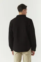 Chaqueta azul marino de paño con cuello clásico, cierre frontal con botones, dos bolsillos de parche en el pecho con solapa abotonada y bolsillos laterales.