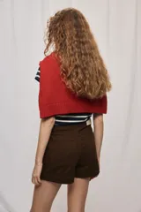 Short de tiro medio y calce ajustado, color blanco, con dobladillos en las piernas y cierre frontal con botón.