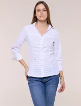 Camisa blanca de poplín de algodón, con silueta semi entallada, cuello camisero con escote en V y pechera frontal con plisado horizontal. Cuenta con abotonadura de strass plateado, mangas tres cuartos con puños anchos vueltos y paneles laterales elásticos.