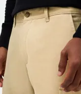 Bermuda cargo de sarga color beige, con bolsillos laterales utilitarios, cierre de cremallera y botón.