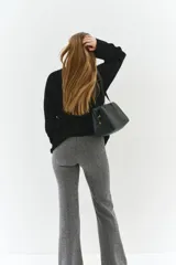 Pantalón de tiro alto con corte acampanado, confeccionado en tejido con patrón de espiga. Presenta cierre frontal oculto y bolsillos traseros insertados.