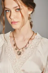 Collar dorado de cadena de eslabones con múltiples dijes de la suerte, incluyendo tréboles, herraduras y estrellas, algunos con incrustaciones de cristal.