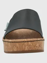 Sandalia tipo slide de Hush Puppies con capellada de cuero negro y banda elástica lateral. Presenta una suela de plataforma alta con acabado de corcho y base de caucho.