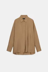 Camisa de corte amplio confeccionada en algodón, con cuello solapa, manga larga con puños y cierre frontal con botones ocultos bajo solapa. Presenta un bolsillo frontal en el pecho.