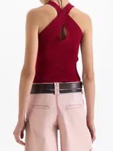 Top tejido de punto acanalado en color negro, con cuello redondo y diseño ajustado al cuerpo. Presenta un corte sin mangas con estilo deportivo y espalda con breteles cruzados.