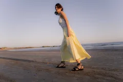 Sandalias bajas de cuero color marrón, con tiras finas para atar alrededor del tobillo.