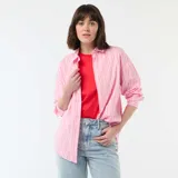 Camisa de manga larga confeccionada en popelina de algodón, con diseño de rayas verticales en tonos rosa y blanco. Presenta cuello clásico, cierre frontal con botones y corte holgado.