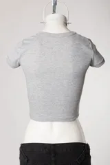 Remera tipo baby tee blanca de manga corta, con cuello redondo y diseño ajustado al cuerpo con estampado y bordado frontal "Red Wings 93".