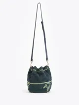 Bandolera tipo bucket bag confeccionada en gamuza color verde oscuro con bordados decorativos en hilo claro. Presenta cierre de cordón ajustable con borlas en los extremos, correa larga regulable de cuero y detalles metálicos dorados.