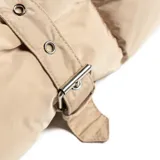 Campera tipo puffer larga con capucha, confeccionada en poliéster acolchado. Presenta cierre frontal doble con botones, bolsillos laterales abiertos y diseño de costuras horizontales.