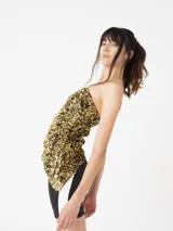 Top strapless asimétrico de lentejuelas plateadas y grises con forro interior y cinta de sujeción.