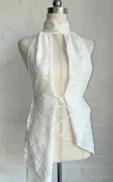 Top blanco con textura, cuello halter y abertura en el frente.