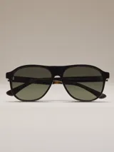 Anteojos de sol estilo aviador con montura negra gruesa y lentes polarizados de color verde oscuro. Las patillas son de carey marrón oscuro.