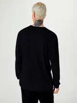 Remera básica de manga larga con cuello redondo, confeccionada en tejido liso de algodón.