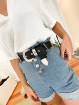 Cinturón negro de cuero vacuno con hebilla plateada estilo western y puntera metálica.