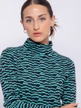 Polera negra con estampado geométrico en blanco, de cuello alto y manga larga.