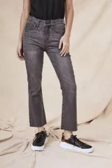 Pantalón de jeans gris oscuro, de corte flare, tiro alto y terminación desflecada.
