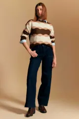 Jean azul oscuro de corte wide leg, con tiro alto, bolsillos frontales tipo parche y bajo deshilachado.