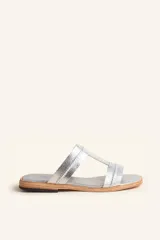 Sandalia plana de cuero plateado con tiras anchas y costuras a la vista, suela de cuero.