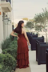 Vestido largo color ladrillo con breteles finos, escote en V y falda con volados en capas.