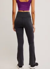 Calza de tiro alto con diseño acampanado en el ruedo, confeccionada en tejido acanalado de color negro. Presenta una costura en forma de V en la cintura y un pequeño logo bordado en la cadera.