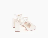 Sandalias de cuero color hueso, con taco alto y ancho, plataforma delantera y tira con hebilla ajustable en el tobillo.