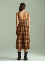 Vestido midi estilo corset con estampado a cuadros en tonos marrón y tostado, con breteles anchos y falda acampanada.