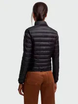 Campera puffer corta Moncler modelo Lans en color negro, con diseño acolchado horizontal, cuello alto y cierre frontal con cremallera doble cursor. Cuenta con bolsillos frontales con solapa y broche a presión.