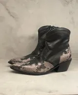 Botas cortas de cuero negro con diseño de serpiente en la puntera y el talón.