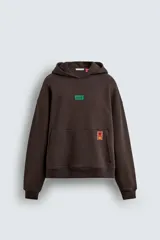 Sudadera con capucha de corte relajado, color marrón oscuro, con interior perchado. Presenta un bolsillo frontal tipo canguro, bordado con la palabra 'LOVE' en el pecho y un parche decorativo a contraste en el bolsillo. Posee puños y ruedo en rib.