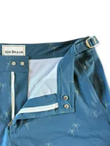 Short de baño con estampado de hojas en tonos verde, marrón y azul sobre fondo azul oscuro.