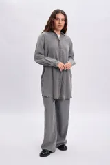 Camisa de jean de corte oversize y largo tipo túnica en color gris desgastado, con mangas largas, cuello camisero y cierre frontal de botones.