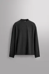 Sudadera de hombre, corte regular fit, color negro oscuro, confeccionada en tejido con lana de textura irregular. Presenta cuello redondo y mangas largas.