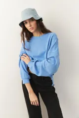 Buzo celeste cropped de manga larga con puños y cordones ajustables en la cintura.