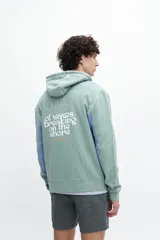 Canguro negro con mangas en color crema y estampado en la espalda con la frase "The sound of waves breaking on the shore".