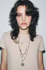 Set de tres collares de diferentes largos, con cadenas de eslabones finos y detalles de bolitas metálicas en tonos dorados y plateados. Incluye un colgante principal en forma de estrella con incrustaciones de cristales y múltiples dijes colgantes en forma de gota con cristales.